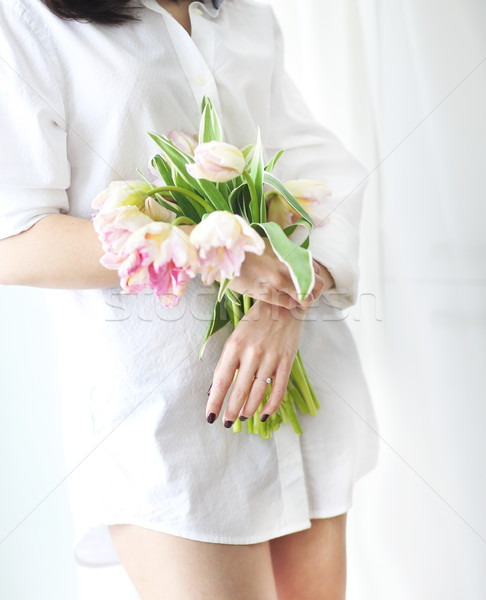 Beautiful young woman holding a bunch of delicate spring pink tu Stock photo © dashapetrenko
