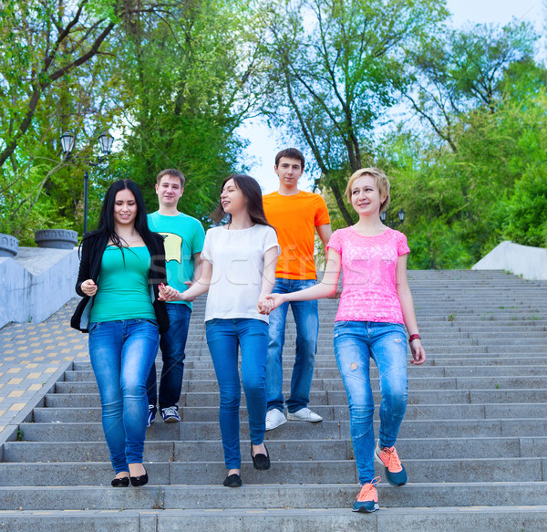 Smiling group of teenagers walking outdoors Stock photo © dashapetrenko