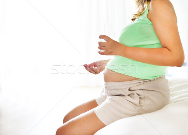 Young pregnant woman with medicine and glass of water Stock photo © dashapetrenko