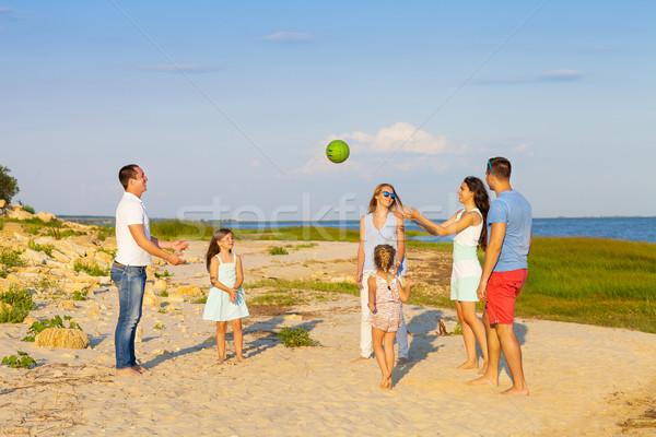 Friends with children playing with the ball on the beach Stock photo © dashapetrenko