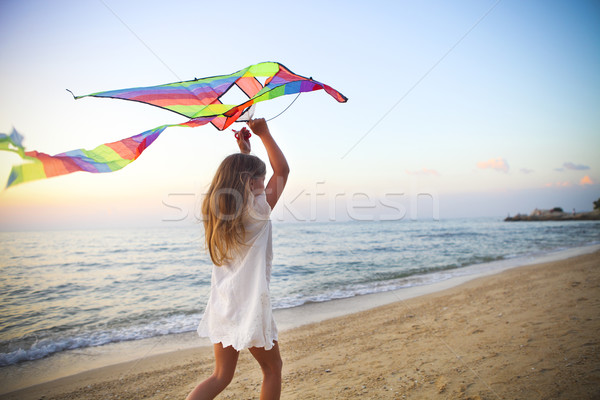 Küçük kız uçan uçurtma tropikal plaj gün batımı küçük Stok fotoğraf © dashapetrenko