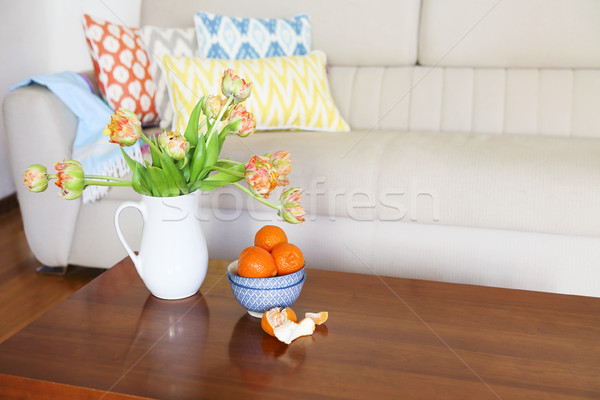Beautiful orange tulips bouquet on wooden table in the living ro Stock photo © dashapetrenko