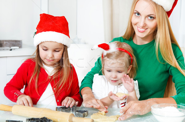 Adorable girls with her mother baking Christmas cookies in the k Stock photo © dashapetrenko