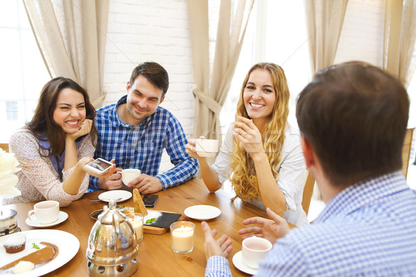 Group of four happy friends meeting and talking and eating desse Stock photo © dashapetrenko