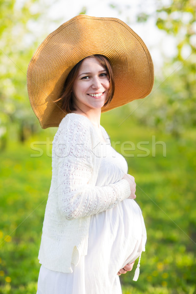 Pregnant woman wearing big hat and white dress in blooming garde Stock photo © dashapetrenko