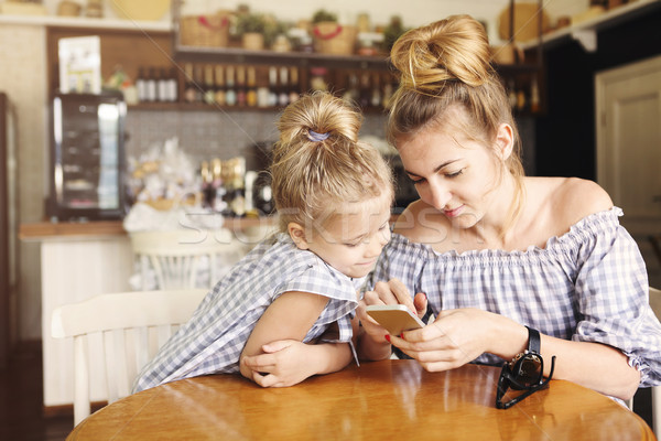 Szczęśliwy matka dziewczynka obiedzie smartphone restauracji Zdjęcia stock © dashapetrenko