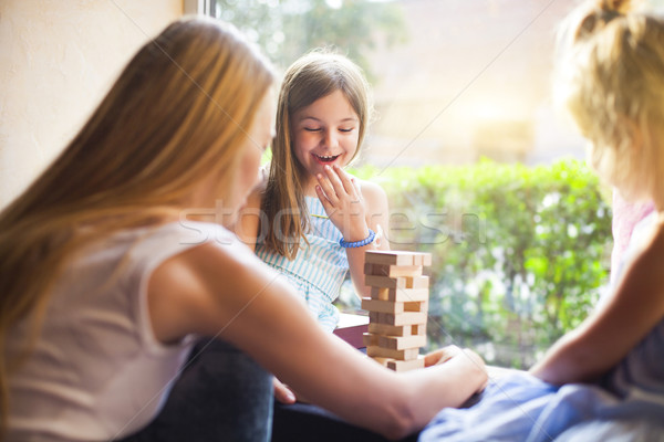 Happy mother with two children playing the wooden blocks tower Stock photo © dashapetrenko