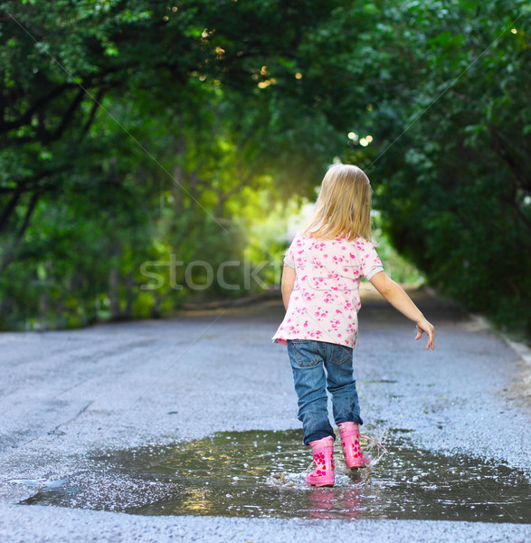 Cute little girl wearing rain boots  Stock photo © dashapetrenko
