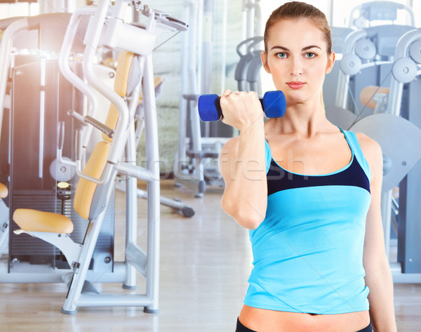 Sporty female doing physical exercise in gym Stock photo © dashapetrenko
