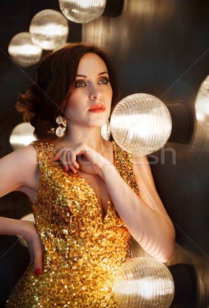 Superstar woman wearing golden shining dress Stock photo © dashapetrenko