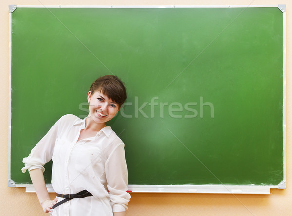 Student girl standing near clean blackboard in the classroom Stock photo © dashapetrenko