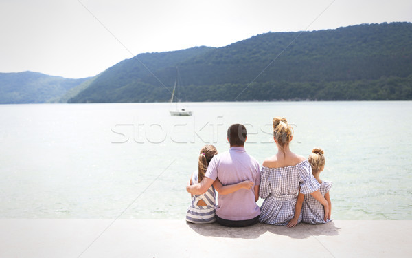 Young family of four sitting by lake  Stock photo © dashapetrenko