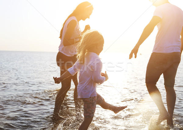 Stock photo: Happy young family having fun running on beach at sunset