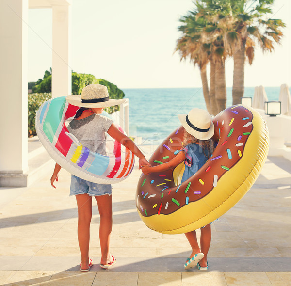 Stock photo: Two small girls with inflatable toys on the beach