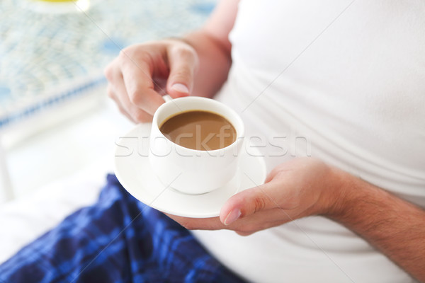 Young man drinking morning coffee in the bed Stock photo © dashapetrenko
