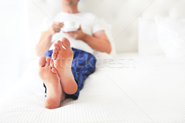 Young man drinking morning coffee in the bed Stock photo © dashapetrenko