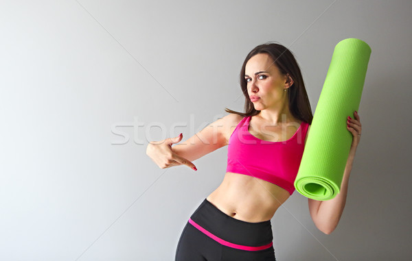 Stock photo: Attractive woman wearing pink sportswear holding green yoga or f