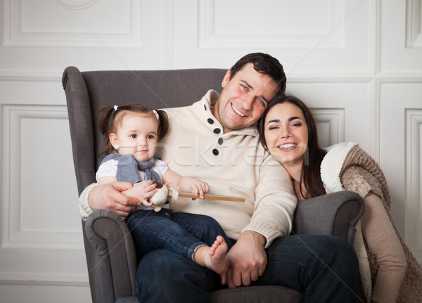 Smiling family with one year old baby girl indoor Stock photo © dashapetrenko