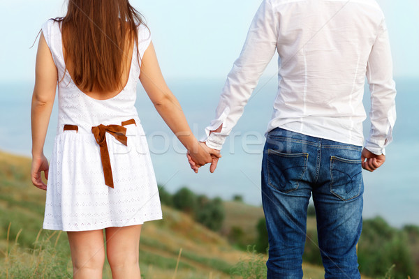 Young couple in love holding hands. Summer sea background Stock photo © dashapetrenko