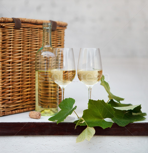 Still life with glasses of white wine, bottle, basket Stock photo © dashapetrenko