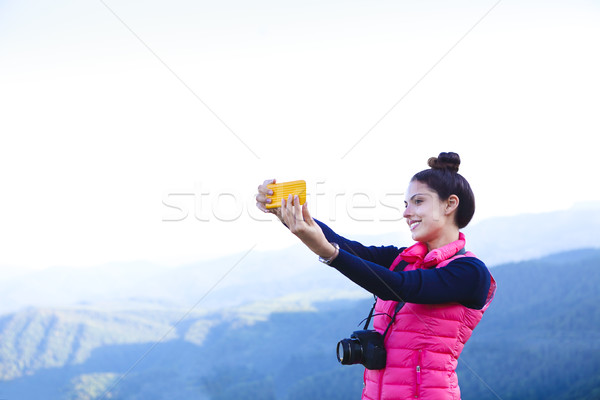 Woman hiker taking photo with smart phone at mountain peak Stock photo © dashapetrenko