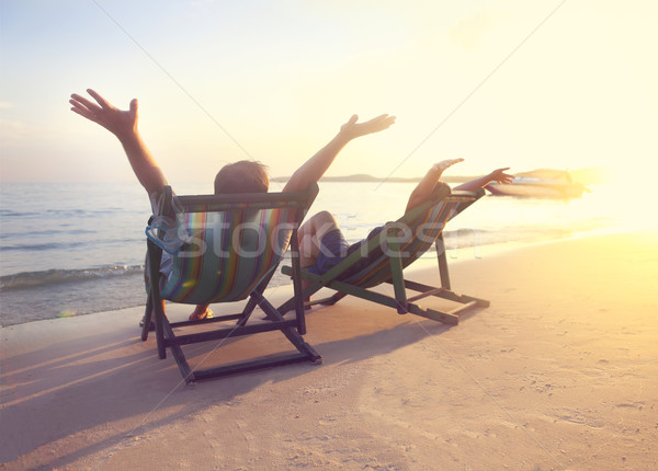 Happy couple sitting at sun chairs on the beach of Koh Samet at  Stock photo © dashapetrenko