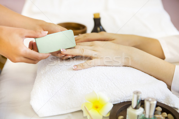 Woman in nail salon receiving manicure by beautician Stock photo © dashapetrenko