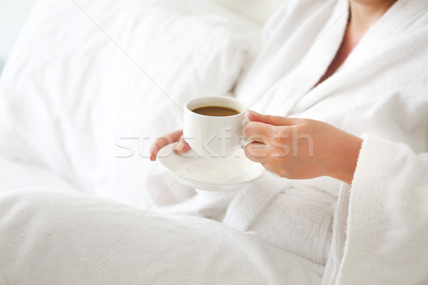 Woman wearing white robe with cup of coffee in her hands Stock photo © dashapetrenko