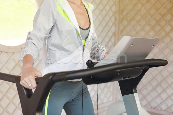 Stock photo: Young sporty woman on treadmill