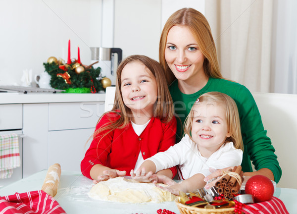 Two adorable girls with mother baking Christmas cookies in the k Stock photo © dashapetrenko
