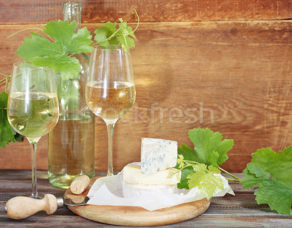 Glasses of white wine, bottle and cheese Stock photo © dashapetrenko