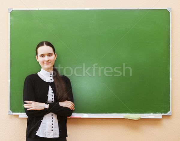 Student girl standing near clean blackboard in the classroom Stock photo © dashapetrenko