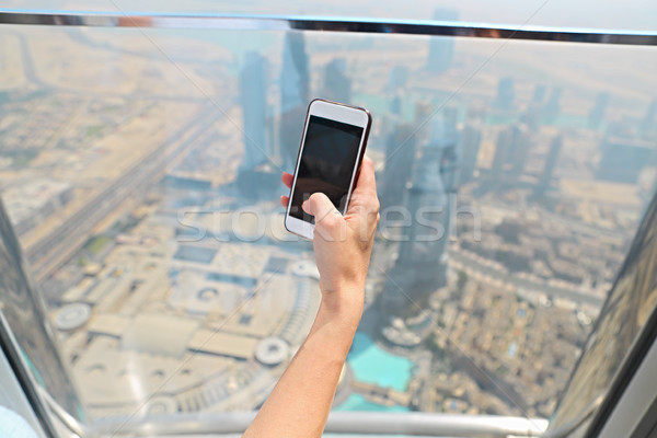 Nina turísticos teléfono móvil ventana rascacielos burj Foto stock © dashapetrenko