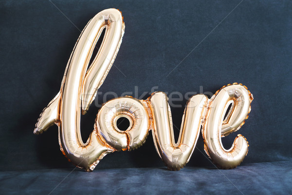 Shaped golden balloon of word Love on dark background Stock photo © dashapetrenko