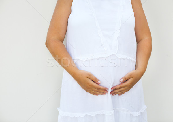 Pregnant woman touching her belly with hands Stock photo © dashapetrenko