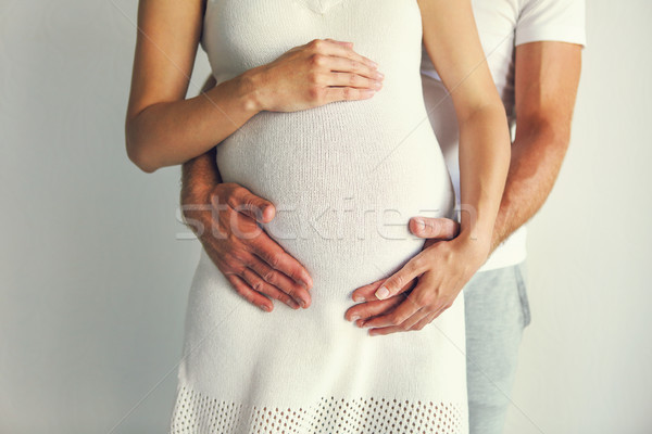 Young man and pretty pregnant woman hugging together Stock photo © dashapetrenko