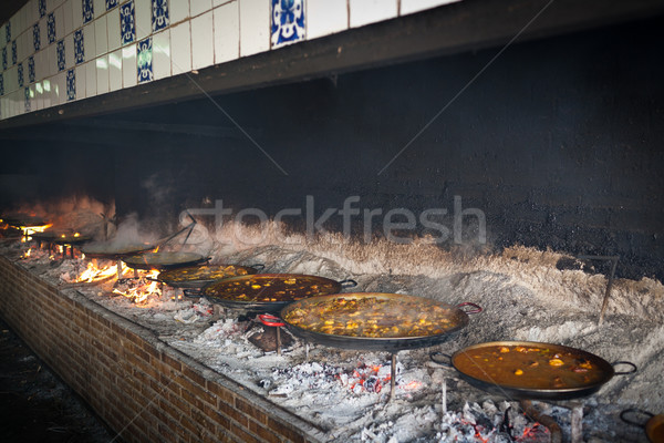 Valencian paella cooking on log fire Stock photo © david010167