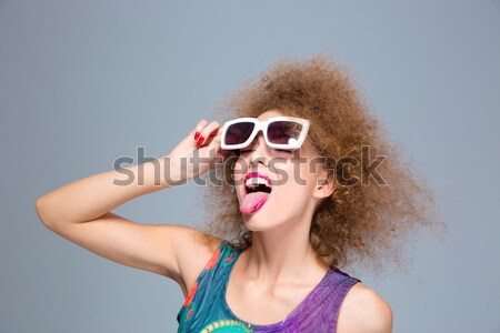 Closeup of young beautiful winking model in green sunglasses  Stock photo © deandrobot