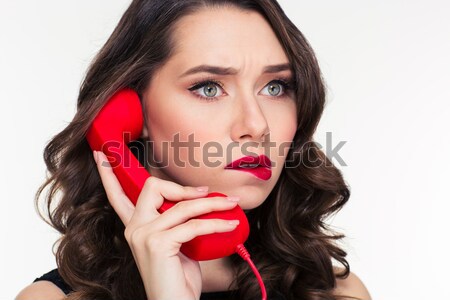Thoughtful beautiful curly woman with retro hairstyle talking on telephone  Stock photo © deandrobot