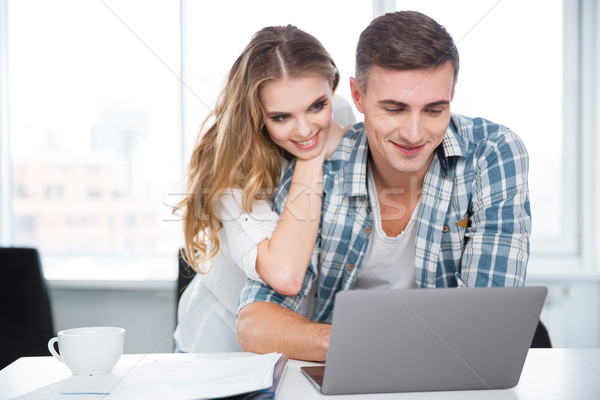 Heureux couple utilisant un ordinateur portable surf internet séance [[stock_photo]] © deandrobot