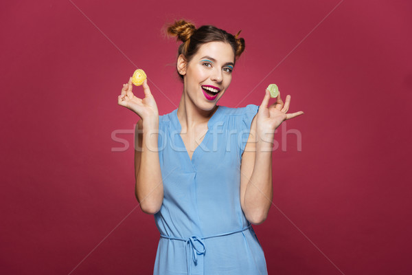 Joyful attractive young woman standing and holding marmalade candies  Stock photo © deandrobot