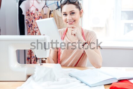 Concentrated woman seamstress working and using tablet in workshop Stock photo © deandrobot