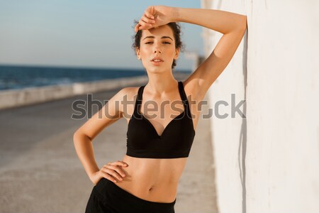 Young sports woman resting after workout at the beach cafe Stock photo © deandrobot