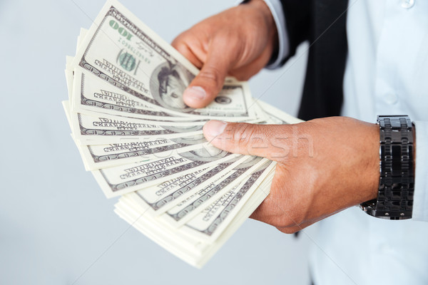 Hands of african young man holding money Stock photo © deandrobot