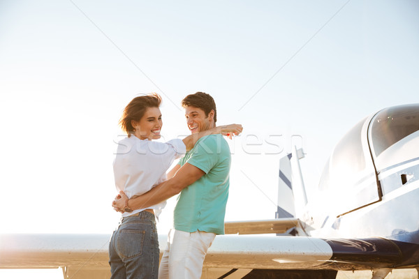 Couple hugging and laughing near private plane Stock photo © deandrobot