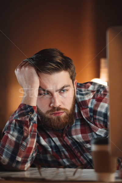 Young tired bearded web designer working late at night Stock photo © deandrobot