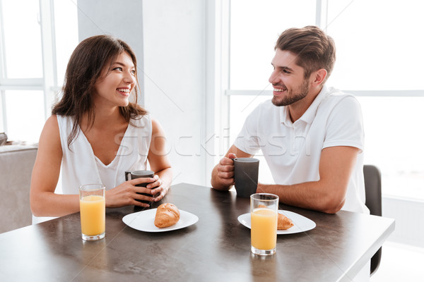 Couple sitting and drinking coffee at the table on kitchen Stock photo © deandrobot