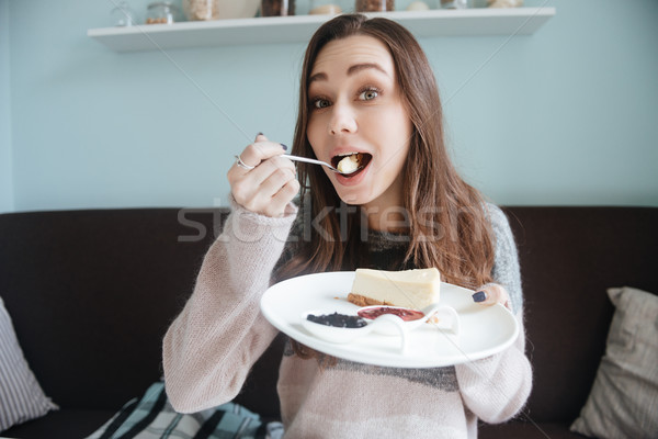 Happy young woman sitting in cafe and eating cake Stock photo © deandrobot