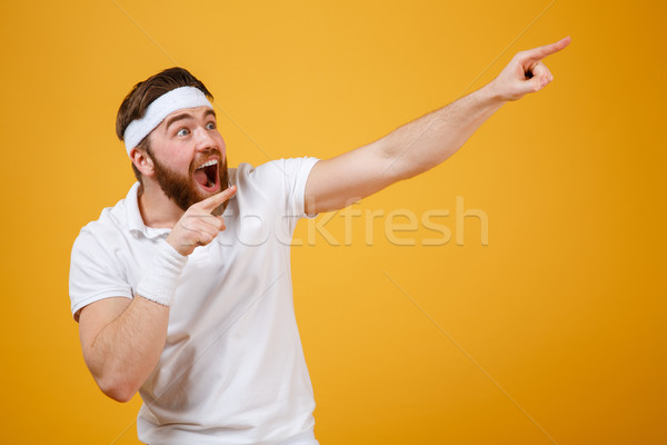 Screaming sportsman pointing away Stock photo © deandrobot