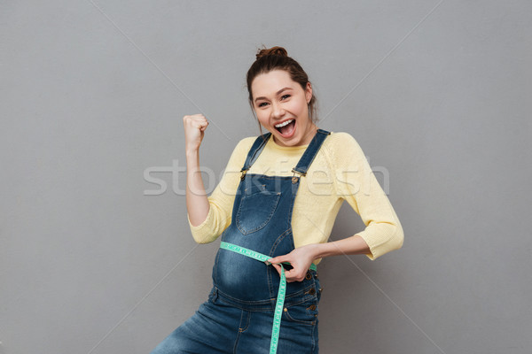 Pregnant happy woman with centimeter Stock photo © deandrobot